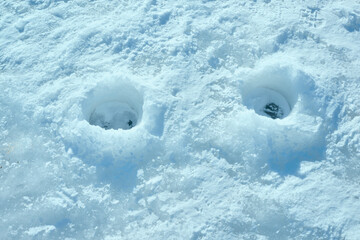 ワカサギ釣りのために氷上に開けられた穴