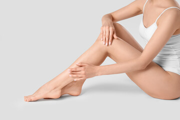 Woman with beautiful smooth legs on white background, closeup