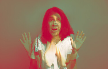 Paranoia. Multiple exposure with photos of emotional woman, color toned