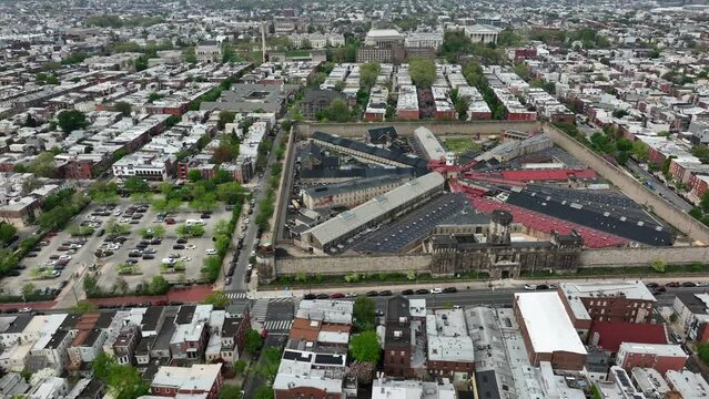 Aerial drone truck shot of Eastern State Penitentiary in urban Philadelphia neighborhood. Famous historial prison among rowhomes and urban community. Correctional facility, city neighborhood theme.