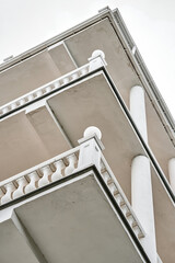 Vintage building with multi level balconies decorated with classic style concrete fences and...