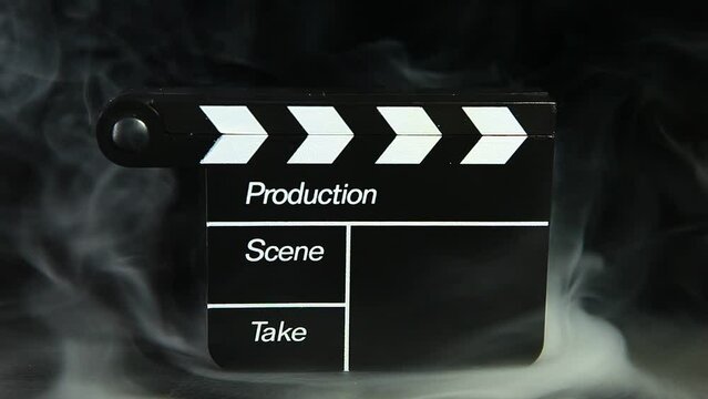 footage of clapper board smoke dark background 