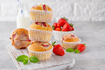 Homemade strawberry muffins or cupcakes on a board on a gray background. Selective focus. Copy space