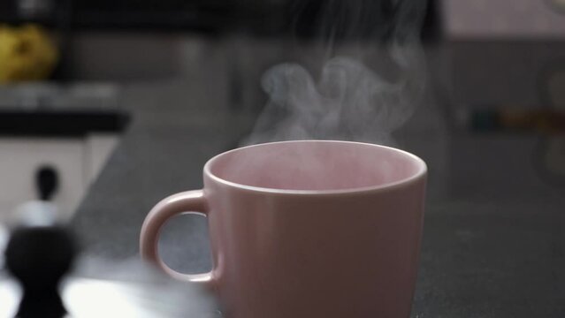 steam comes out of the cup, fresh coffee in the morning at home to start the day with energy.

