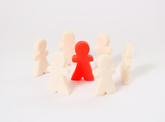 Red plasticine figure among white figures