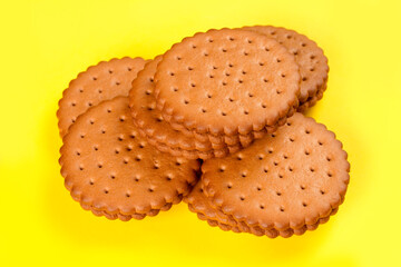 Round cookies with filling on a yellow background.