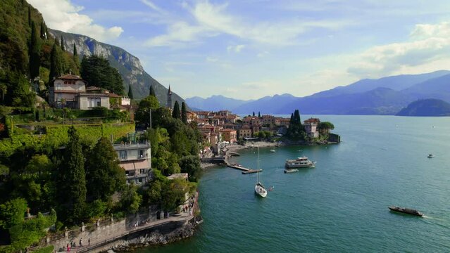 Varenna, an amazing small town on Lake Como in Northern Italy, from a drone during a sunny day in summer. Villas and Green Gardens on the lake from above