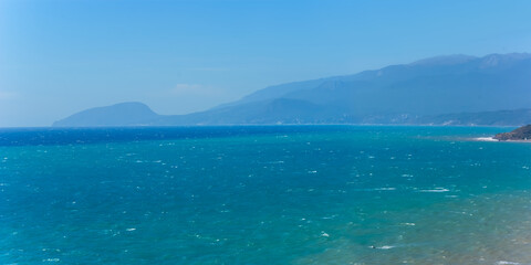 emerald sea bay with mount  silhouette on coast