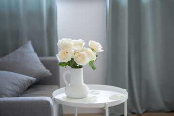 bouquet of white roses in white jug in modern interior