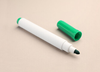 Bright green marker on beige background, closeup. School stationery