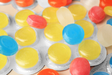 Blisters and many colorful cough drops as background, closeup