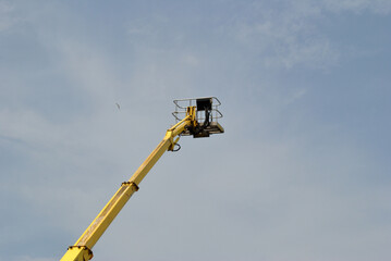 Obraz premium Extended Hydraulic Arm with Platform seen against Sky 