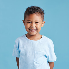 Happy, portrait and a child with a smile for dental care isolated on a blue background in a studio....