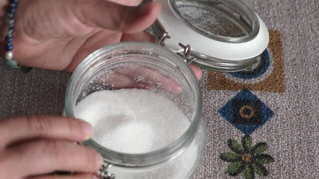 sugar pot and small metal spoon stirring sugar, take sugar to pour it into drink
