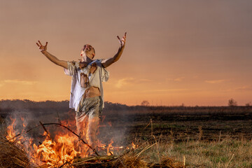 young guy crying in fire in burnt clothes asking God for help, war, house destruction, human disappointment