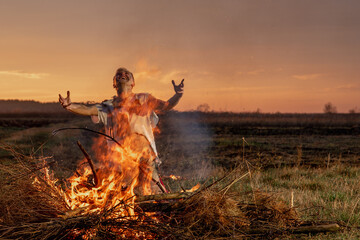 young guy crying in fire in burnt clothes asking God for help, war, house destruction, human disappointment