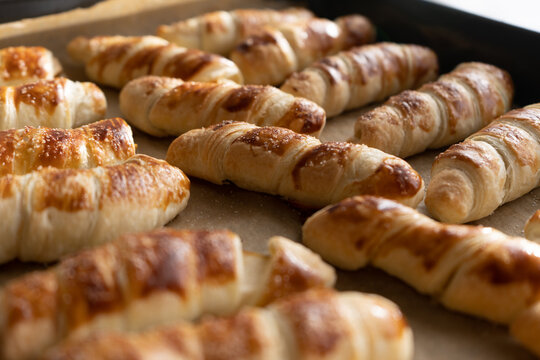 Close-up of baked uff pastry buns with pear on a baking sheet on the kitchen table at home