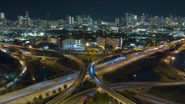 View from above of american big freeway intersection in Miami, Florida at night with fast moving cars and trucks. Timelapse video of USA transportation infrastructure