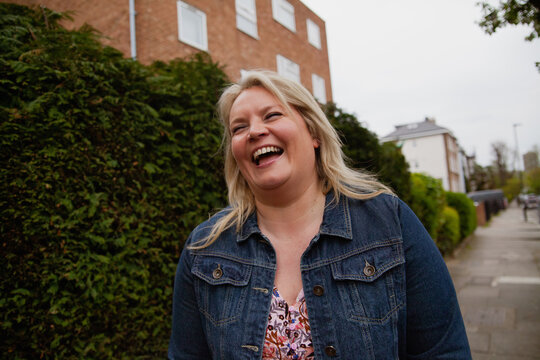 Portrait of plus-sized woman wearing a jeans jacket and dress in the neighborhood