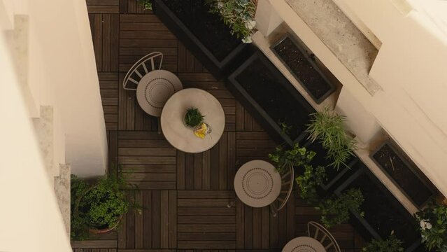 Hotel patio in Paris with table and chairs, filmed from directly above. 