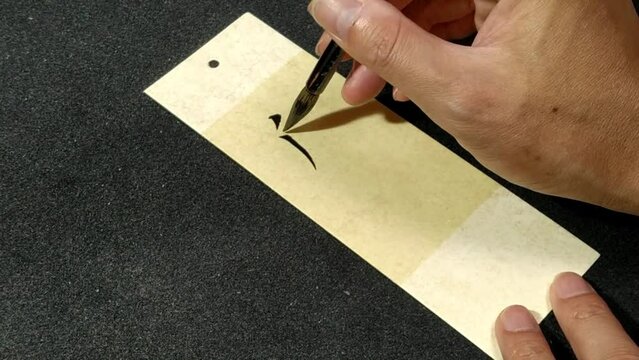 Writing Chinese Calligraphy characters, translation: "Wisdom" on bookmark card.