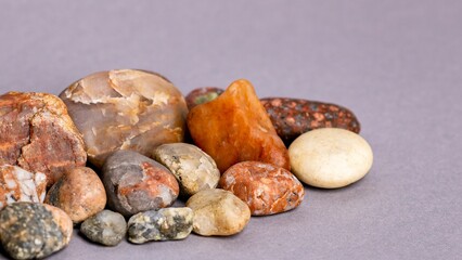 Closeup of a heap of pebbles on a gray background. Holistic Medicine concept.