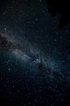Vertical shot of Milky Way illuminating a dark night sky