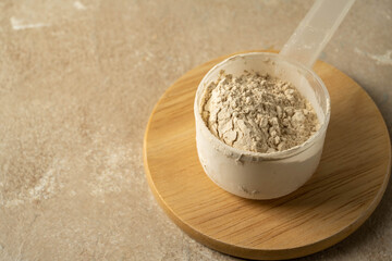 Protein powder in a scoop with two glasses of protein drink. Bodybuilding, fitness sport, health and nutrition.