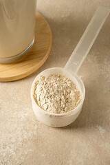 Protein powder in a scoop with two glasses of protein drink. Bodybuilding, fitness sport, health and nutrition.