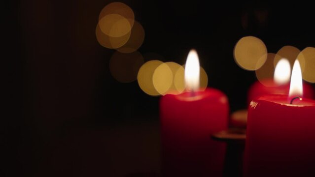 Close-up view of burning candles with a background of Christmas bokeh lights