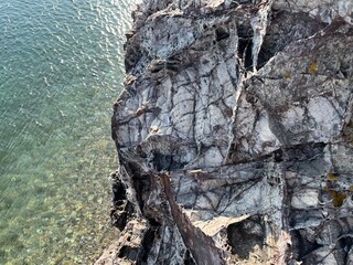 Grey rocky stone surface near the blue sea water