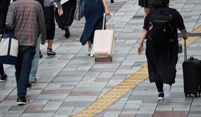 街で歩くスーツケースを持っている観光客の姿