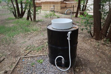 Outdoor hands washing sink made with barrel. Old water tank in the garden. D.I.Y faucet. 