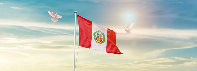 Waving Flag of Peru in Blue Sky. The symbol of the state on wavy cotton fabric.