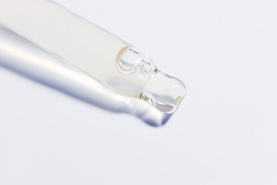 Transparent pipette with gel on a light background.