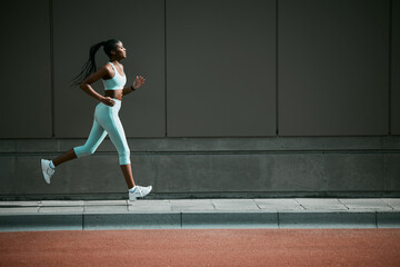 Black woman, running and city sidewalk with training, exercise and fitness on urban road. Street, runner profile and female athlete with mockup and body workout for health, wellness and race outdoor
