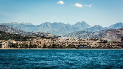 Fototapeta premium Waterfront cityscape against a mountain range background