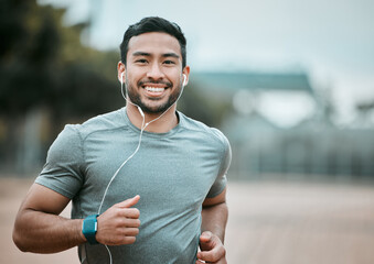 Fitness, portrait and man running with earphones for music, radio or sport podcast for motivation. Sports, exercise and male athlete runner doing outdoor cardio workout for race or marathon training. - Powered by Adobe