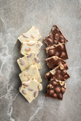 White and dark chocolate bars on kitchen table. Top view.