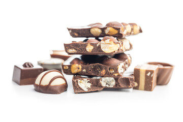 Broken chocolate bars with  nuts and pralines isolated on white background.