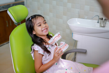 This cute girl is getting ready for her regular dental appointment at the dentist's office checkup.pediatric medical care concept.