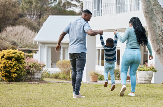 Mother and father lifting child by their new home in the outdoor garden while playing together. Backyard, bonding and back of African parents holding their boy kid in the backyard of their house.