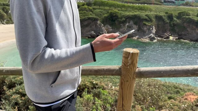 Close up view of male hands using smartphone scrolling, browsing, surfing internet, social media browsing slow motion
