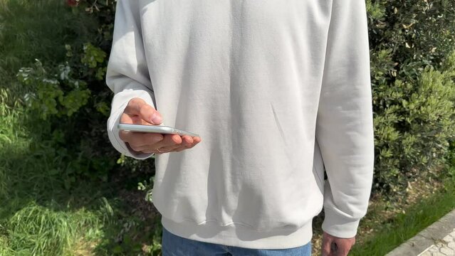 Close up view of male hands using smartphone scrolling, browsing, surfing internet, social media browsing slow motion