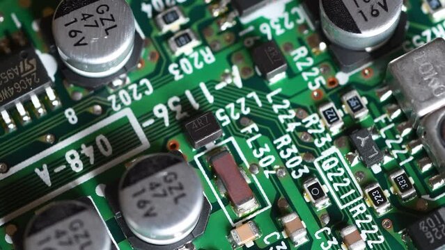 Circuit board with components in rotation. Extreme close up of green electronic board, with electronic components.