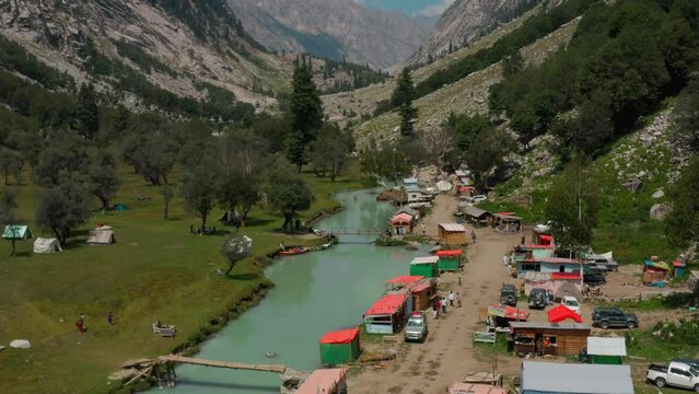 Aerial view of a river flowing through green mountains in Shahi Bagh, Pakistan
