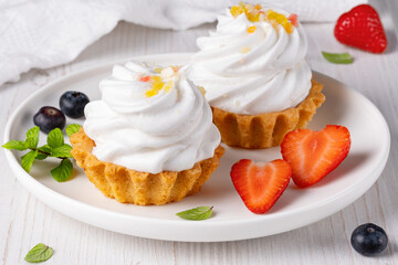Cake basket with blueberry and strawberries on a light table
