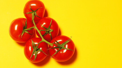 Ripe tomatoes on yellow background