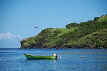 Beautiful shot of a green boat on bright blue water under a sunny sky