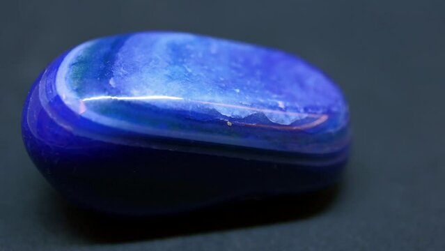 Macro shot of blue agate mineral on purple background